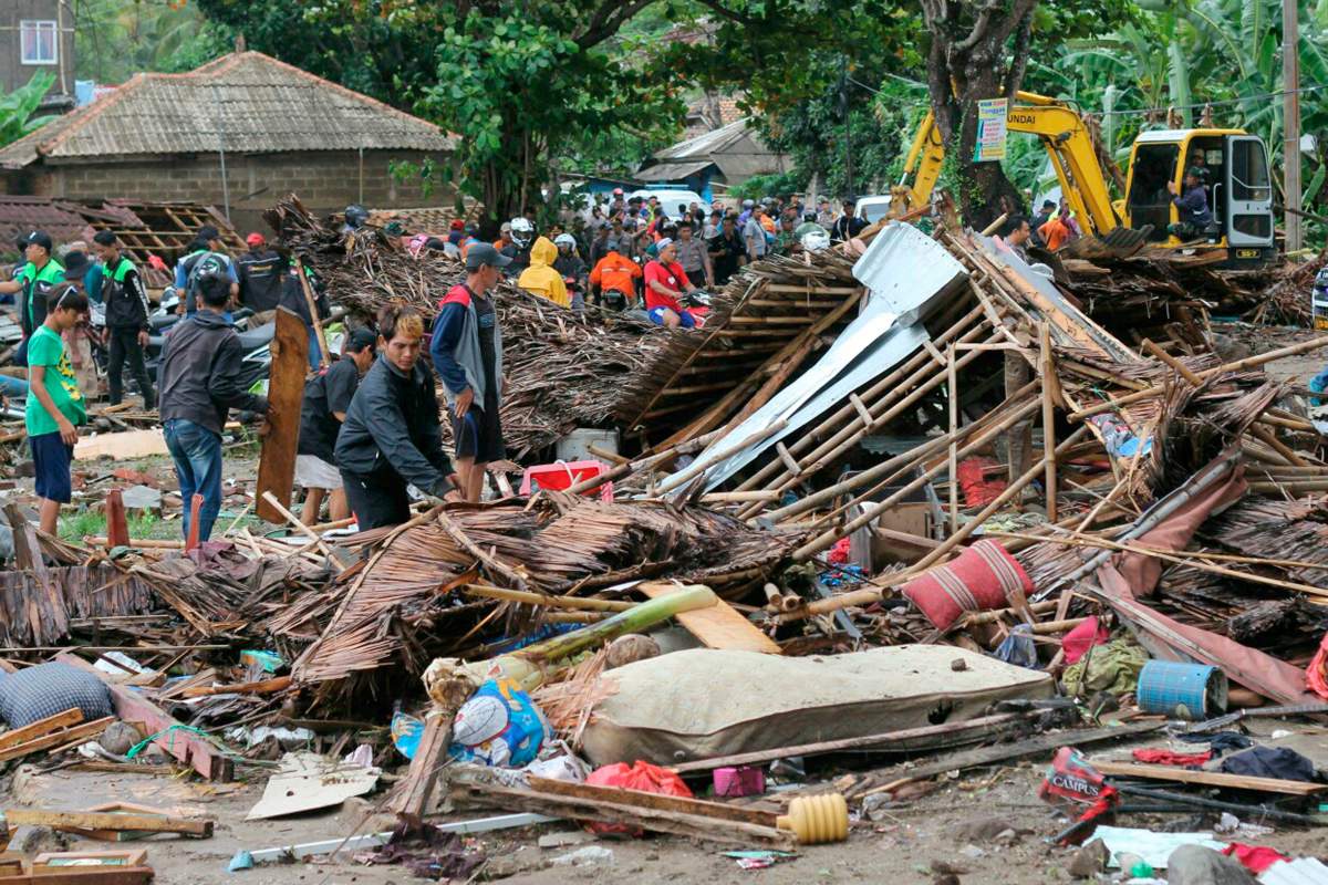 Residents inspect a house damaged by a tsunami in Carita, Indonesia, Sunday, Dec. 23, 2018.
