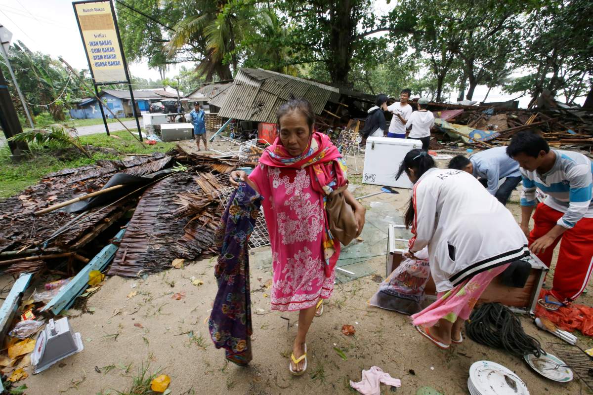 A women inspects her house which was damaged by a tsunami in Carita, Indonesia, Sunday, Dec. 23, 2018. 