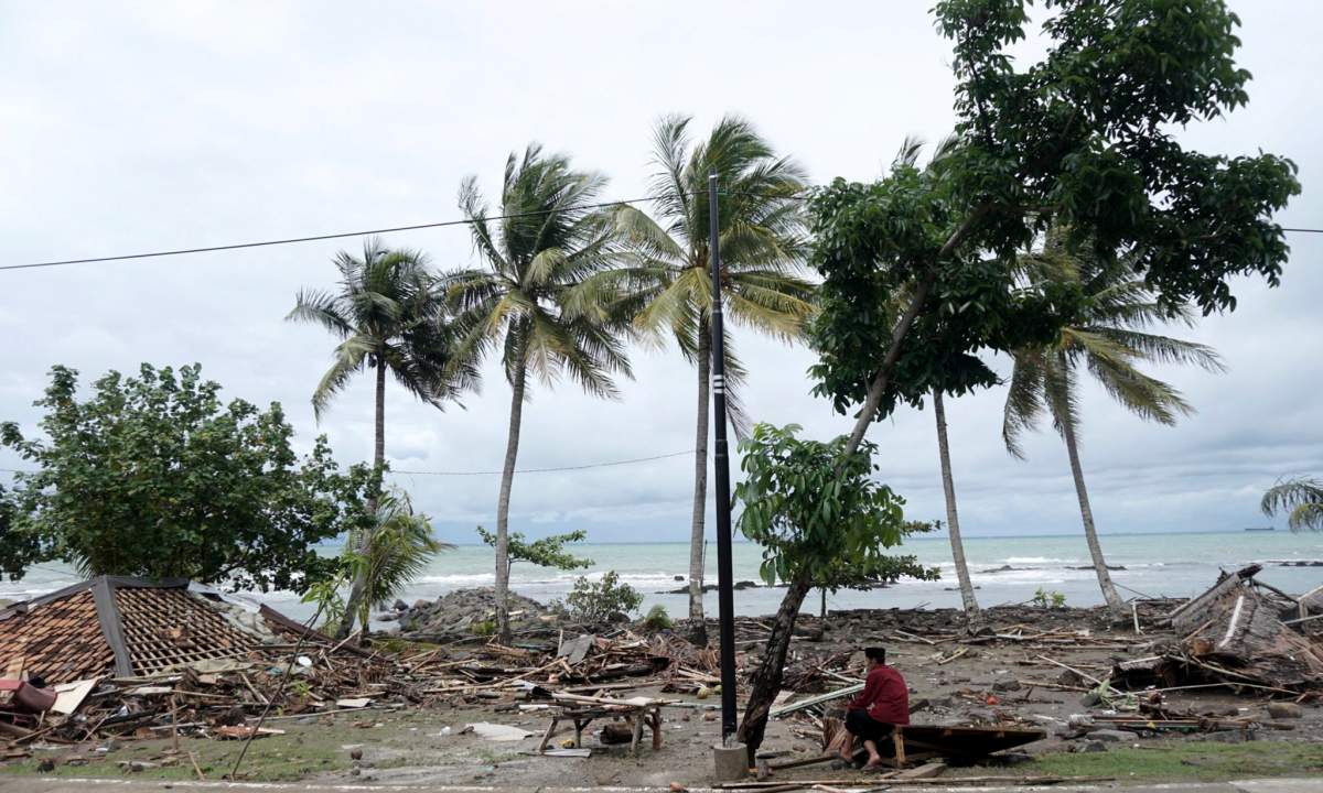 An Indonesian man sits down among the ruins of houses after a tsunami hit Sunda Strait in Anyer, Banten, Indonesia, Dec. 23, 2018.