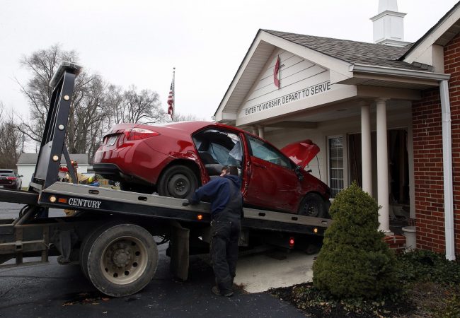 A car that crashed into the entrance of the Crossroads United Methodist Church is towed out of the doorway on Sunday, December 23, 2018 in Columbus, Ohio. A