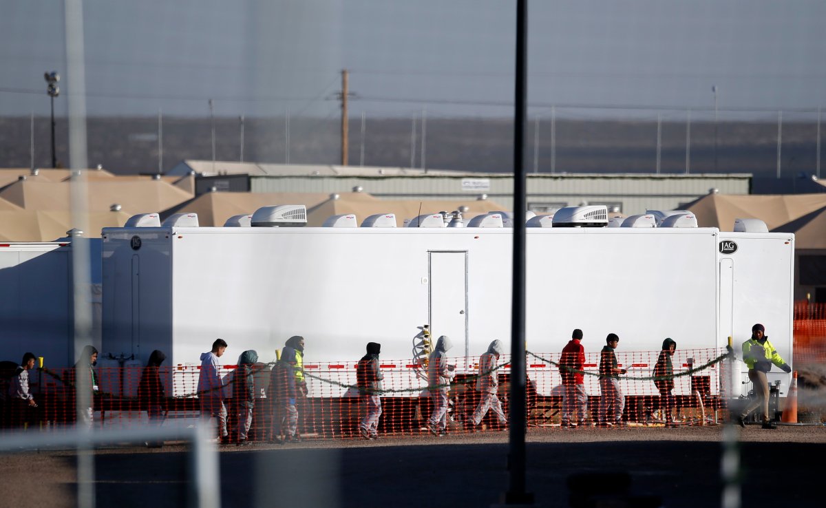 FILE - In this Dec. 13, 2018 file photo migrant teens walk in a line through the Tornillo detention camp in Tornillo, Texas. The Trump administration says it will keep the tent city holding more than 2,000 migrant teenagers open through early 2019. The announcement was made Wednesday, Dec. 26, 2018 about the Tornillo facility, which opened in June in an isolated corner of the Texas desert for up to 360 children.