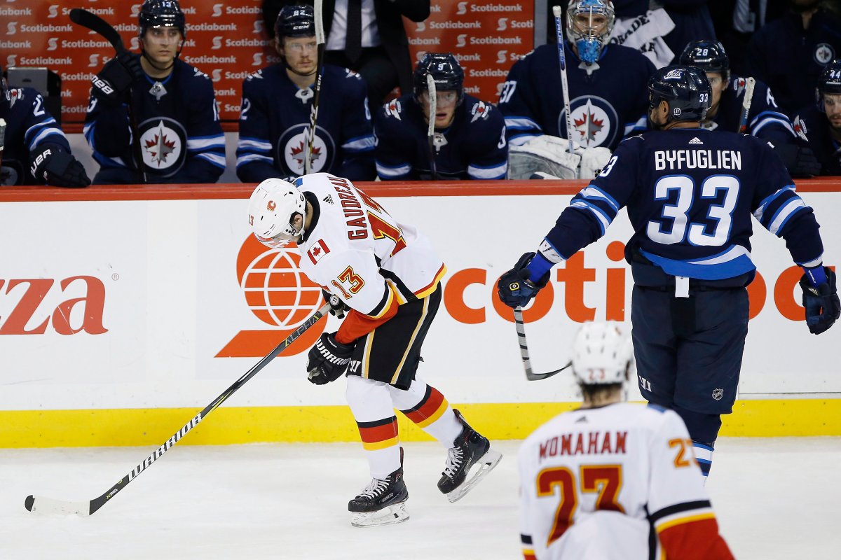 Calgary Flames' Johnny Gaudreau (13) reacts after scoring his hat-trick and getting slashed by Winnipeg Jets' Dustin Byfuglien (33) during third period NHL action in Winnipeg on Thursday, December 27, 2018. 
