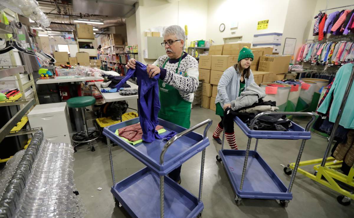 Chris Meyer, left, and Maddi Heim, fold and sort donated clothes at Treehouse, a nonprofit organization in Seattle that serves the needs of children in the foster-care system. The charity was one of several that received donations from the $11-million secret estate of Alan Naiman.