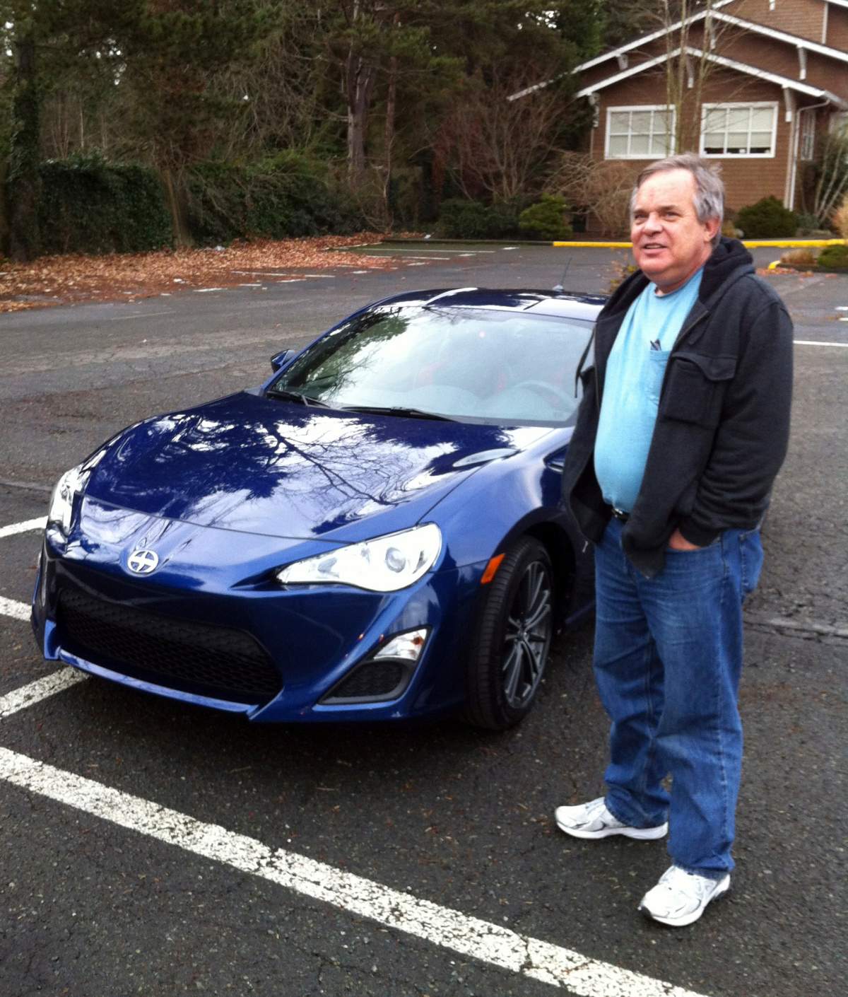 Alan Naiman poses with his new car, an unusual extravagance for him, in Seattle.