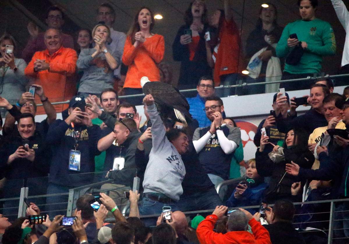 Fans cheer as Clark the bald eagle lands on the arm of a fan in the upper deck after the playing of the national anthem before the first half of the NCAA Cotton Bowl semi-final playoff football game, Dec. 29, 2018, in Arlington, Texas.
