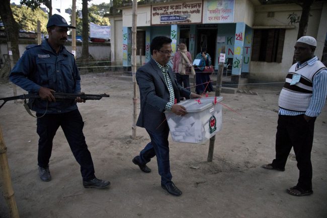 A Bangladeshi polling official carries a ballot box after the polling ended at a polling station in the ancient city of Panam Nagar, about 20 kilometers (12 miles) southeast of Dhaka, Bangladesh, Sunday, Dec. 30, 2018.