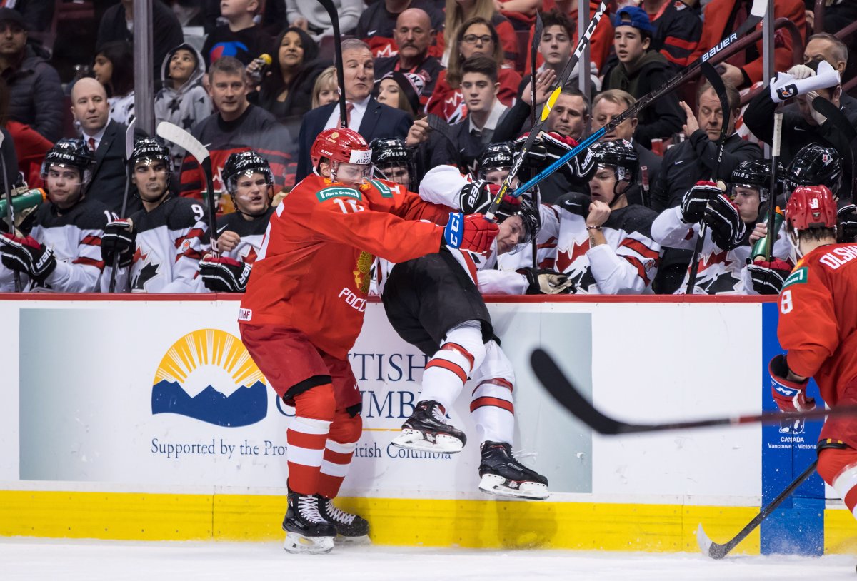 Russia's Pavel Shen, left, checks Canada's Barrett Hayton during second period IIHF world junior hockey championship action in Vancouver on Monday, Dec. 31, 2018. 