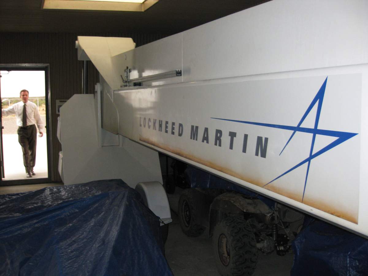 Steve Landeene, New Mexico spaceport’s executive director, is silhouetted in the doorway of a cover building at the spaceport’s vertical launch pad near Upham, N.M., on May 21, 2009. The Lockheed Martin logo is visible on the rail, which holds a 20-foot rocket before liftoff.