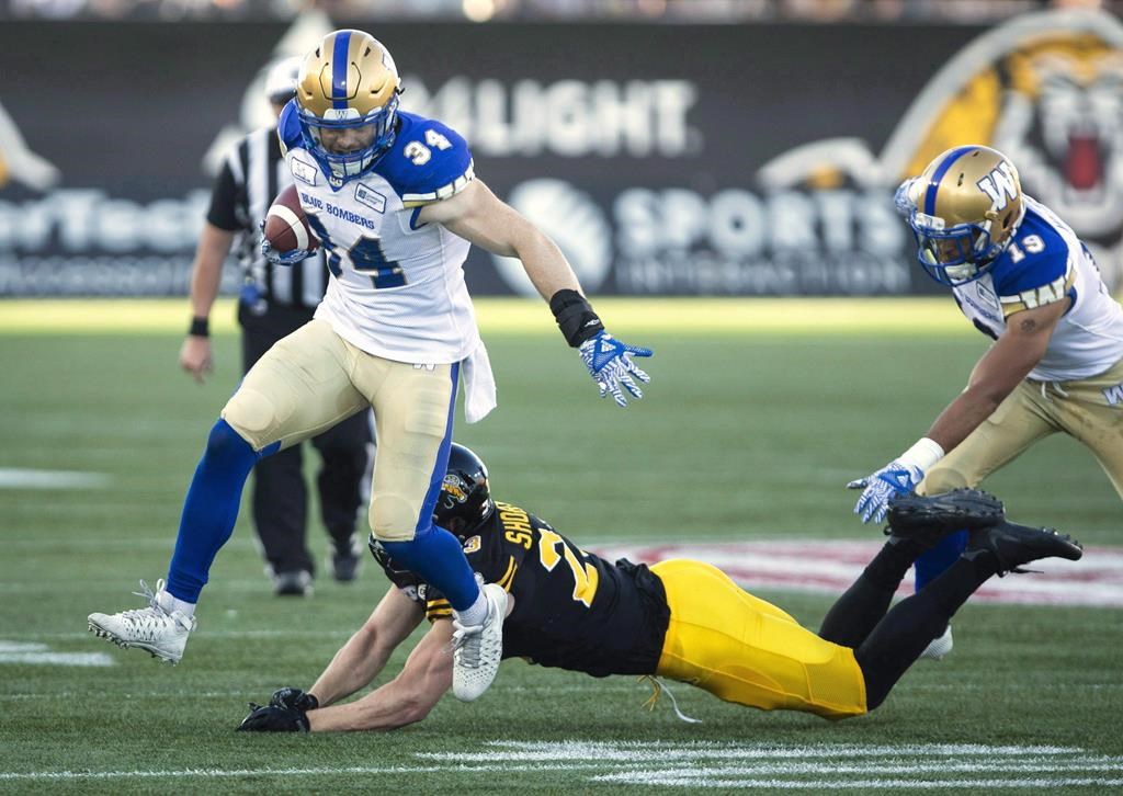 Winnipeg Blue Bombers linebacker Jesse Briggs (34) eludes a tackle by Hamilton Tiger-Cats linebacker Nick Shortill (23) during a faked punt to get a first down during first quarter CFL game action in Hamilton, Ont., on June 29, 2018.