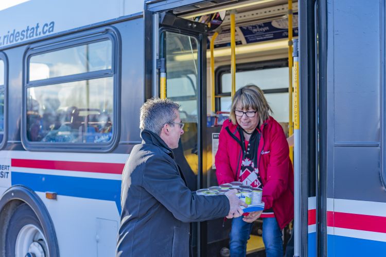 Brian Cyr and members of the Kinette Club of St. Albert fill a transit bus full of donated toys and food.