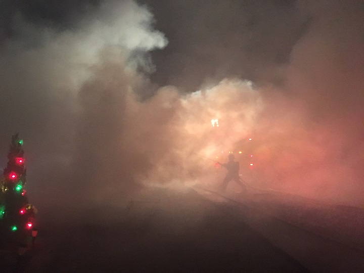 A firefighter, seen here battling the blaze, is enveloped by thick smoke. 