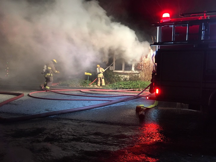 Firefighters extinguish hot spots during Friday night’s blaze.