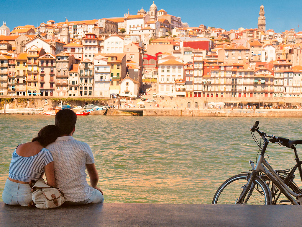 A couple sitting on a pier in the area of the Ribeira do Douro, Portugal. Getty Images