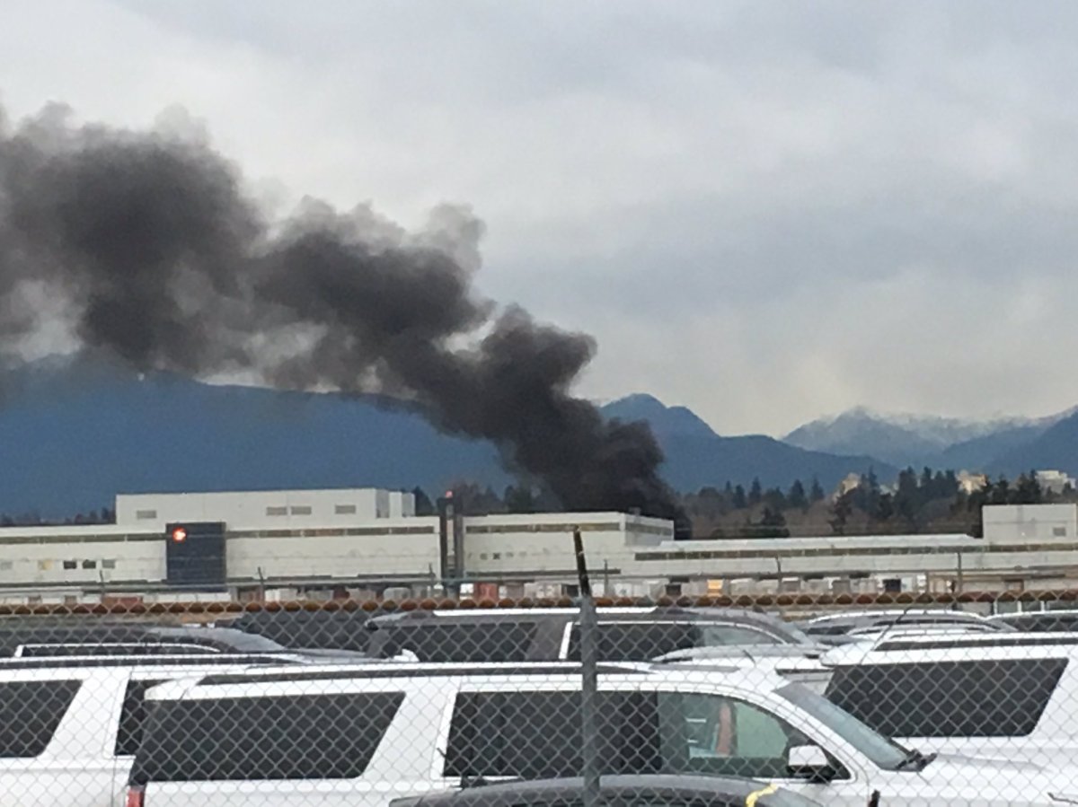 A thick plume of black smoke was visible over a Canada Post facility at YVR on Friday. 