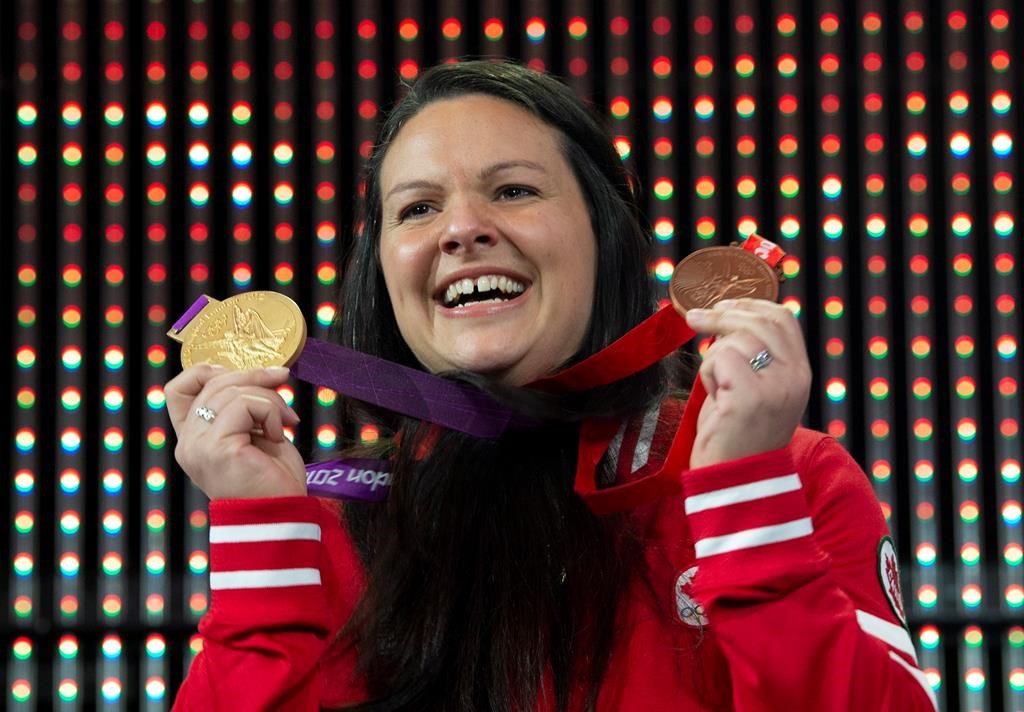 Canadian weightlifter Christine Girard holds up the gold and bronze Olympic medals she was awarded during a ceremony Monday December 3, 2018 in Ottawa. Girard was awarded the London 2012 gold and Beijing 2008 bronze medals after the International Olympic Committee disqualified athletes from the 2008 and 2012 Olympic games.