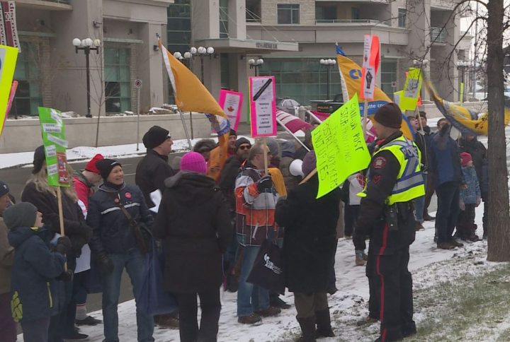More than 150 people from different unions rallied in downtown Calgary as the snow flew on Saturday.