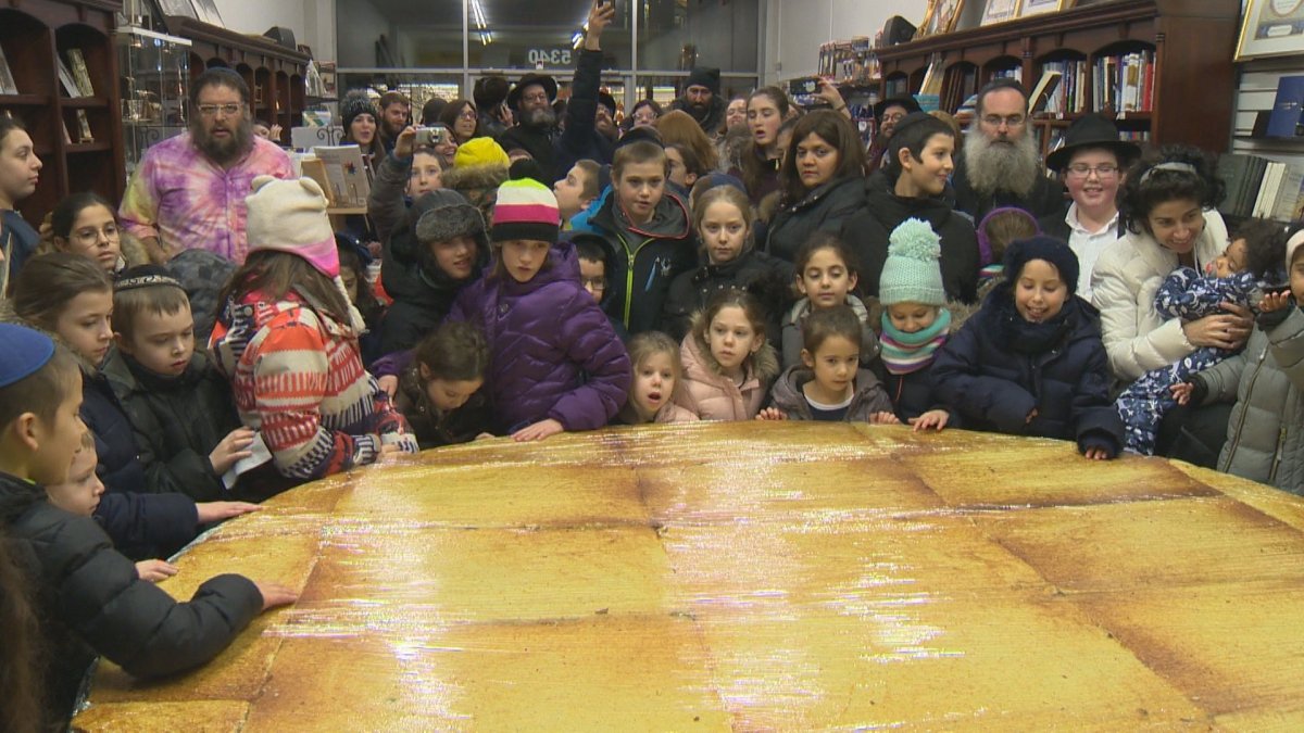 families gather around a two hundred pound latke at Rodals bookstore. Tuesday, December 4, 2018.