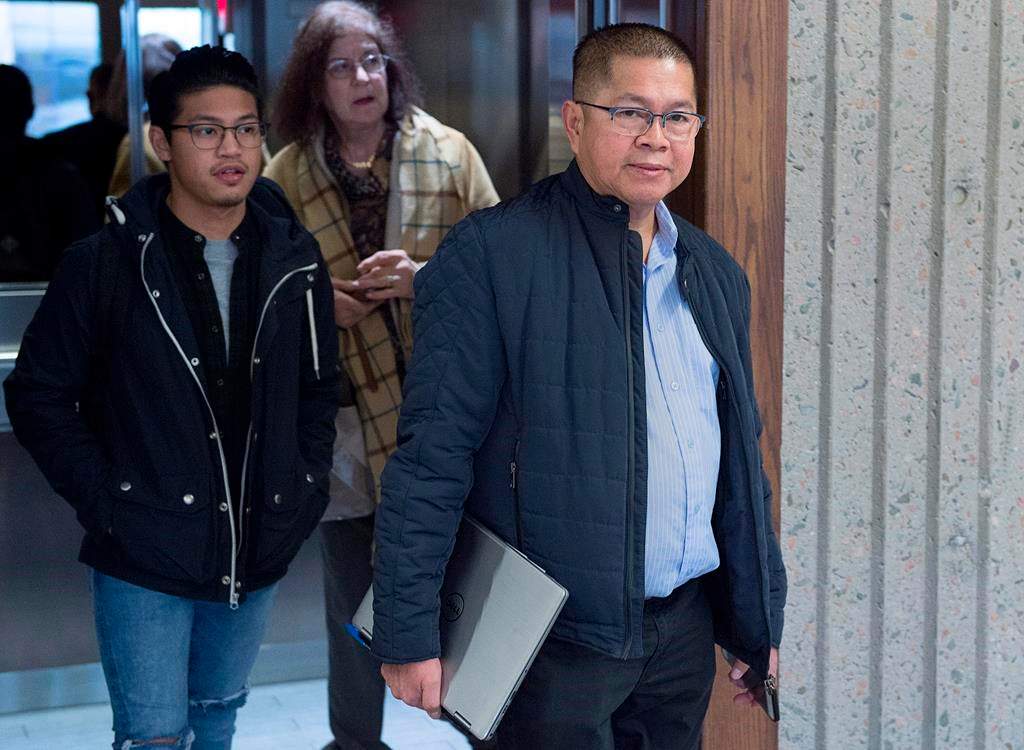 Hector Mantolino, right, charged with not paying Filipino temporary workers their required wages, arrives at Nova Scotia Supreme Court for his sentencing hearing in Halifax on Monday, Dec. 3, 2018.