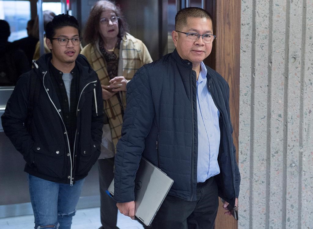 Hector Mantolino, right, charged with not paying Filipino temporary workers their required wages, arrives at Nova Scotia Supreme Court for his sentencing hearing in Halifax on Monday, Dec. 3, 2018.