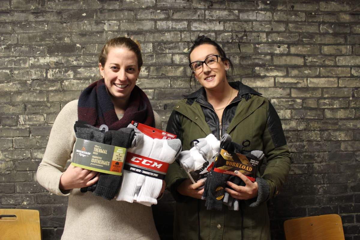 Amber Irvine and Allison DeBlaire hold some of the more than 12,000 socks their campaign has collected for London’s homeless.