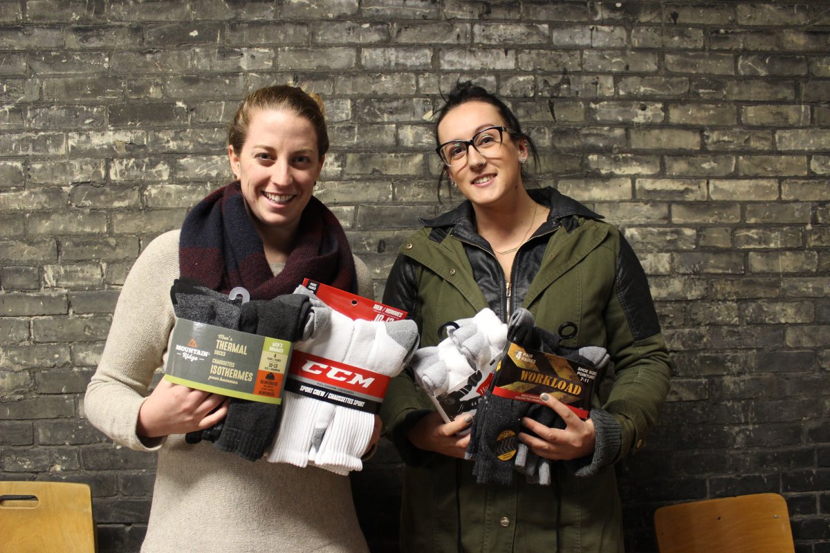 Amber Irvine and Allison DeBlaire hold some of the more than 12,000 socks their campaign has collected to far for London's homeless. 