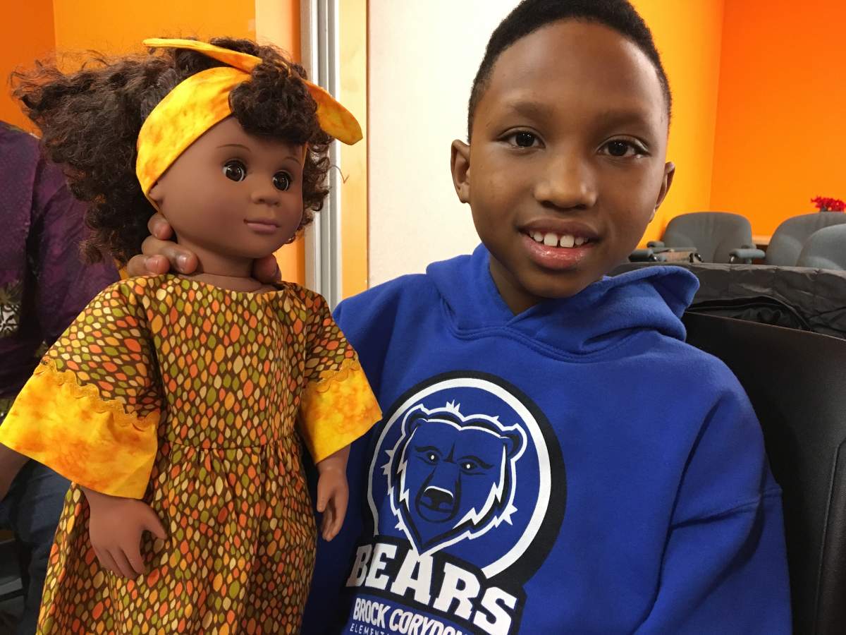 Seven-year-old Isimbi Kavene holding one of the new dolls from the Touch of Kindness program.