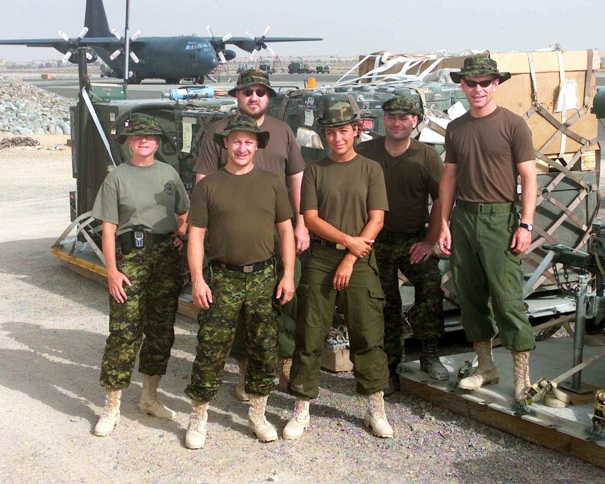 Capt. Kimberly Fawcett, far left, with fellow military members loading pallets in Afghanistan.