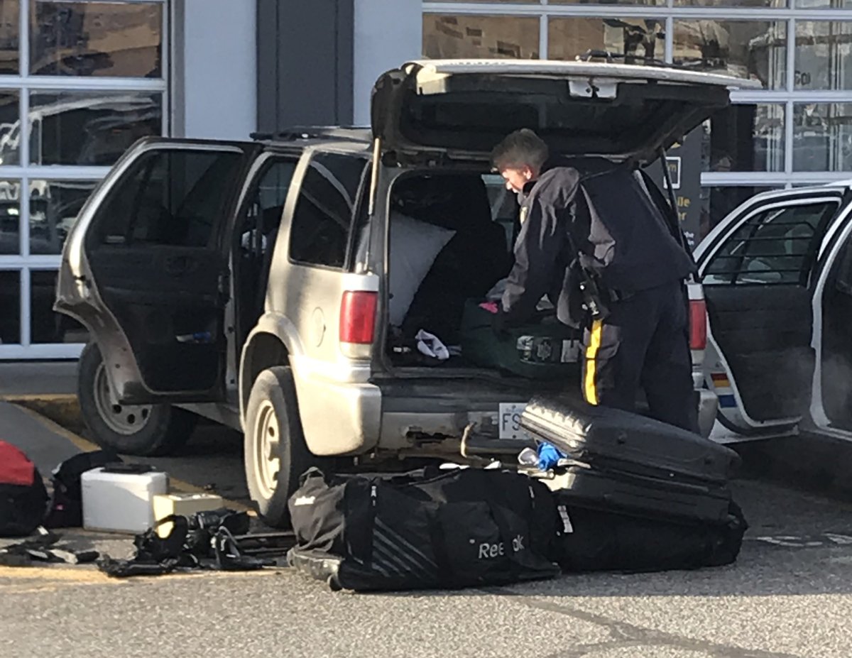 An RCMP officer searching a vehicle in Vernon on Thursday morning. 