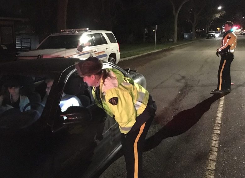 RCMP officer checking driver at checkstop in Kelowna, BC, Dec 20, 2018. 