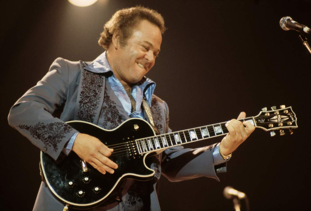 Roy Clark, U.S. country music singer and musician, playing the guitar on stage during a live concert performance, in 1979.
