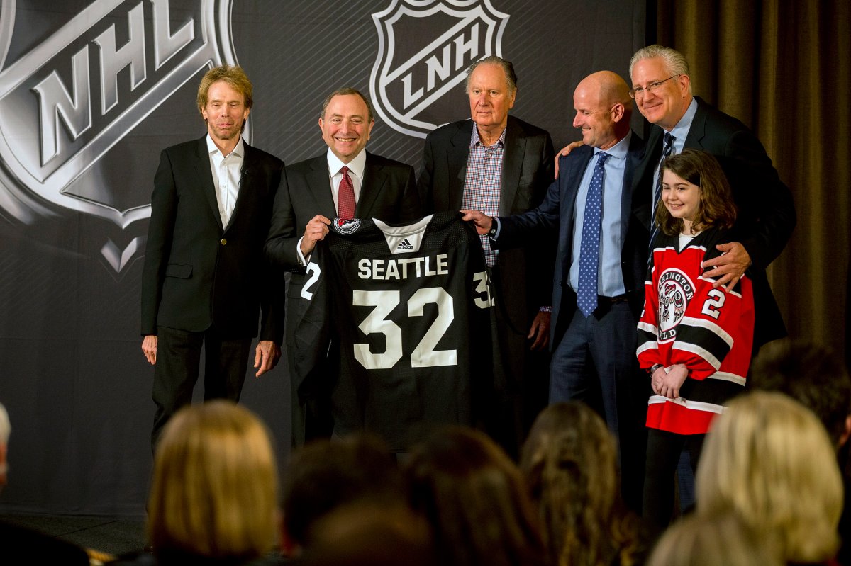 NHL commissioner Gary Bettman, center left, holds a jersey after the NHL Board of Governors announced Seattle as the league's 32nd franchise, Tuesday, Dec. 4, 2018, in Sea Island Ga.. Joining Bettman, from left to right, is Jerry Bruckheimer, David Bonderman, David Wright, Tod Leiweke and Washington Wild youth hockey player Jaina Goscinski.