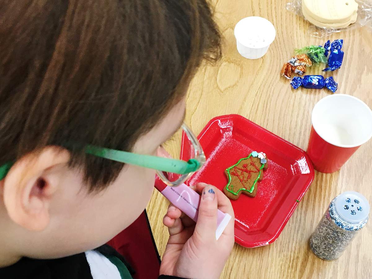 Girls decorate cookies to bring home for the holidays.