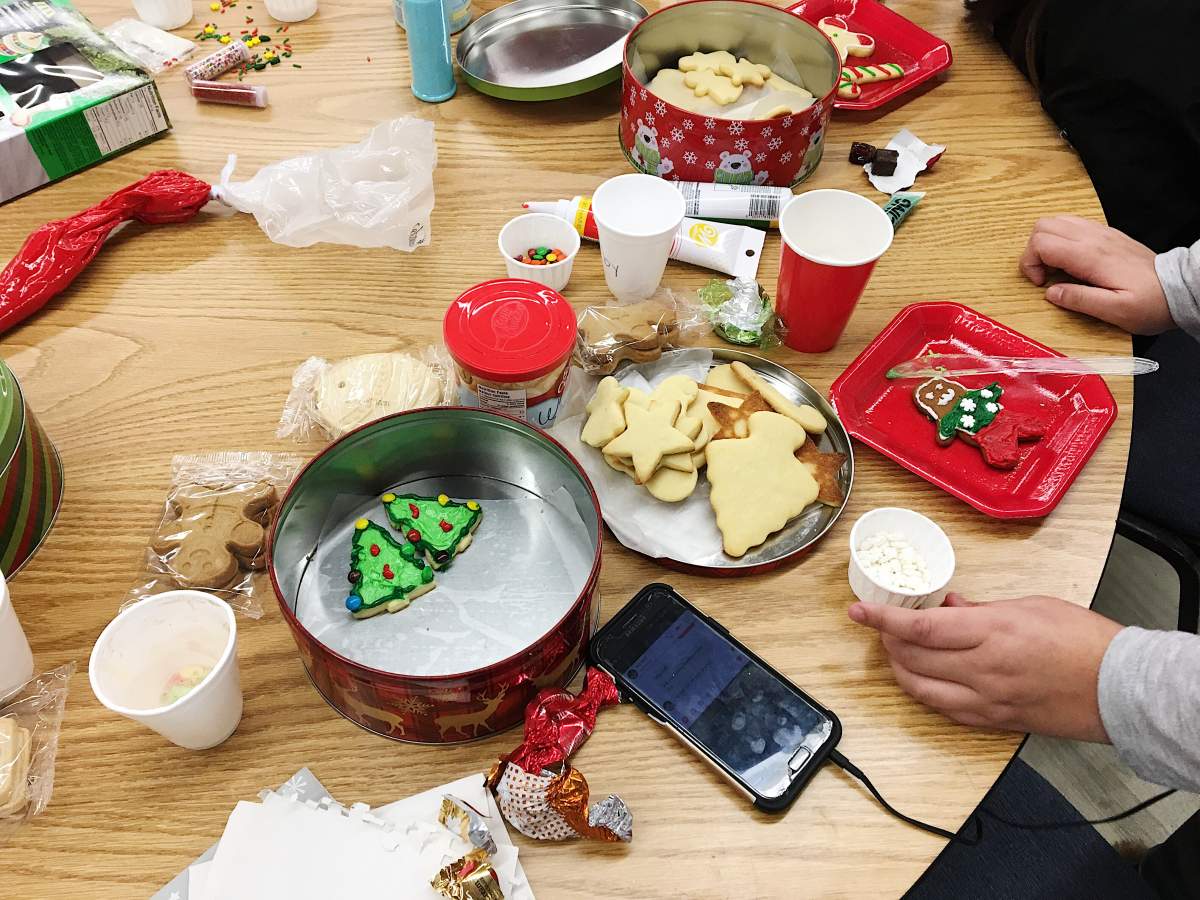 Girls decorate cookies to bring home for the holidays.