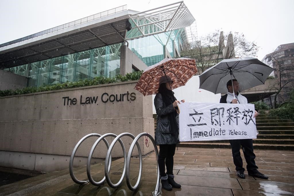 Supporters hold a sign outside B.C. Supreme Court during the third day of a bail hearing for Meng Wanzhou, the chief financial officer of Huawei Technologies, in Vancouver, on Tuesday December 11, 2018.