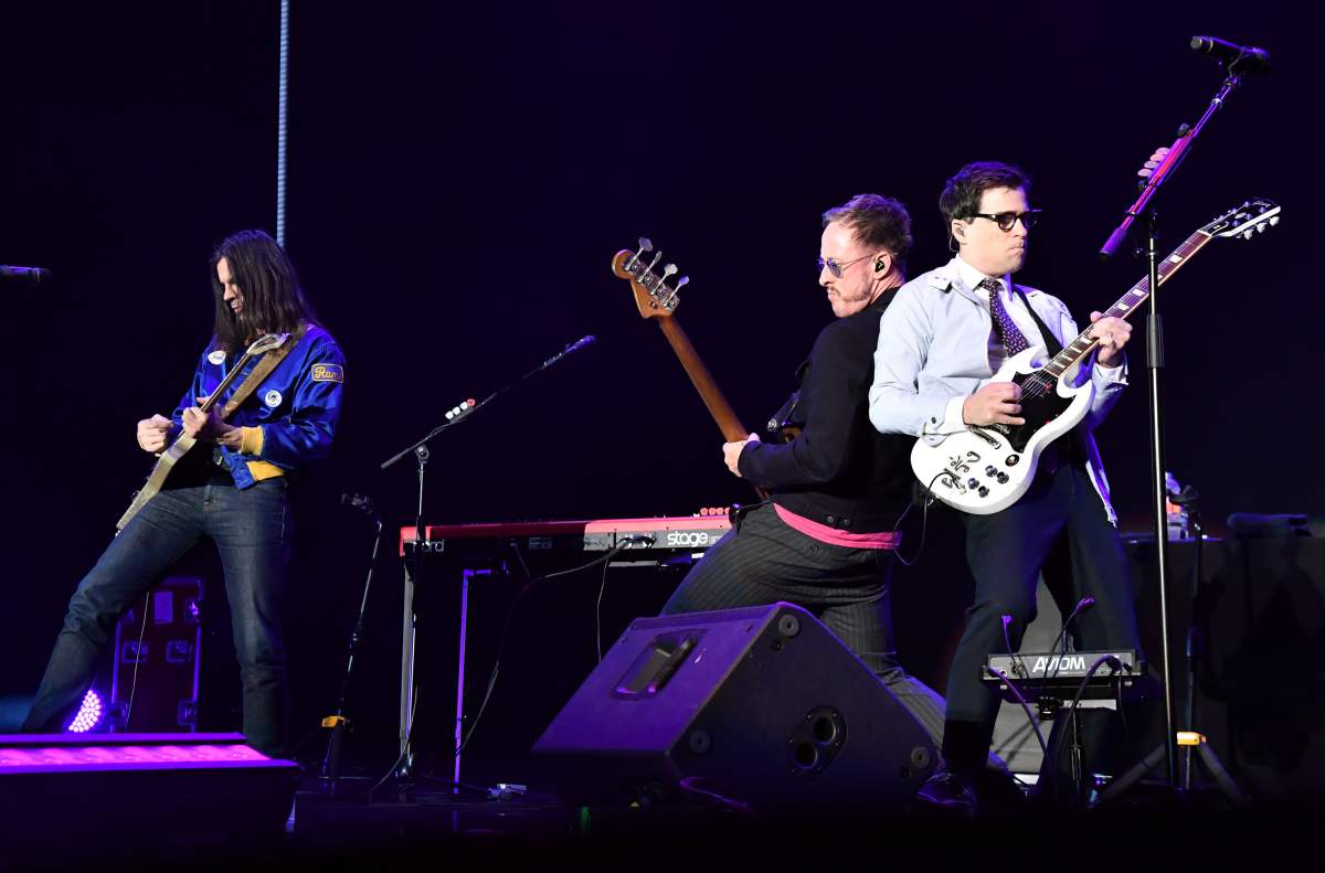 (L-R) Brian Bell, Rivers Cuomo and Scott Shriner of Weezer perform at the KROQ Almost Acoustic Christmas 2017 on Dece. 10, 2017, at the Forum in Los Angeles, Calif.