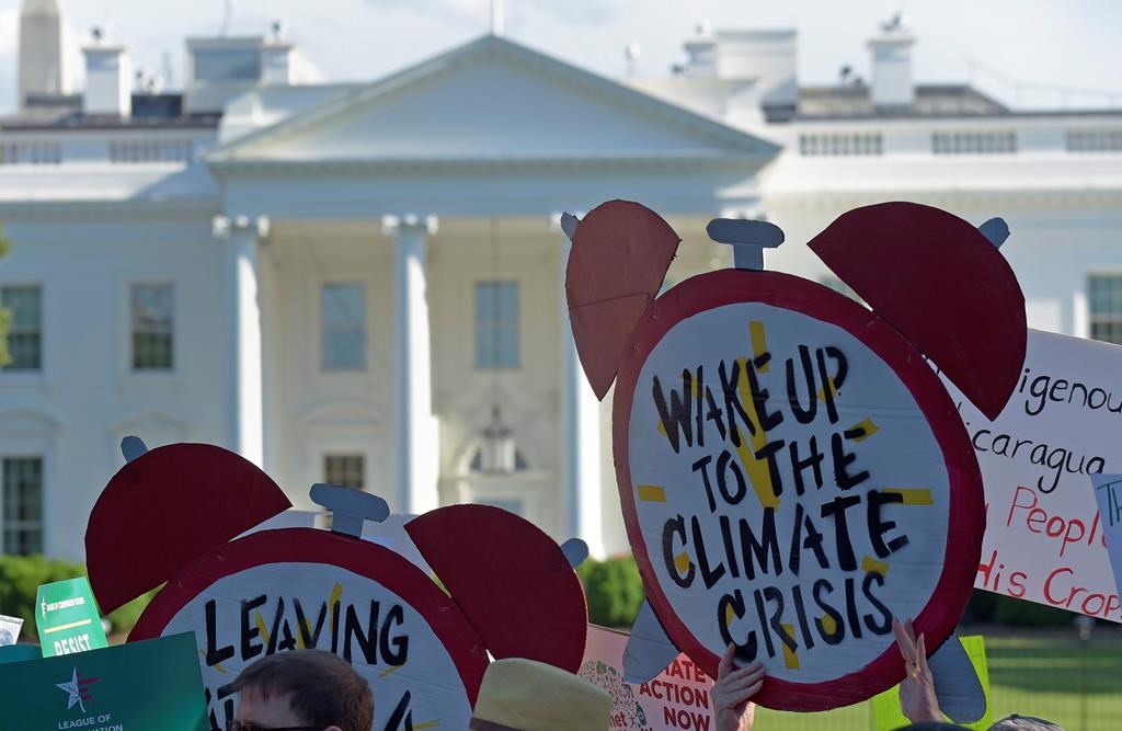 In this June 1, 2017 file photo, protesters gather outside the White House in Washington to protest President Donald Trump's decision to withdraw the Unites States from the Paris climate change accord.