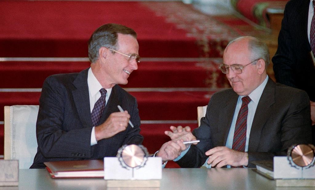 In this file photo taken Wednesday, Aug. 1, 1991, U.S. President George H. Bush and Soviet President Mikhail Gorbachev exchange pens after signing the START arms reduction treaty in the Kremlin, Moscow.