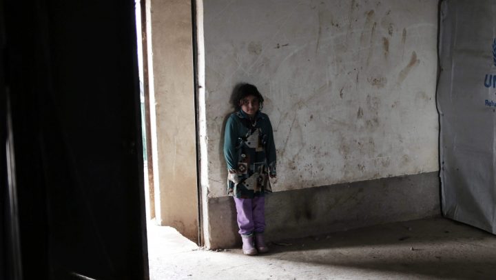 In this file photo, a child stands inside a building in a camp east of Mosul, Iraq, Wednesday, Feb. 15, 2017.