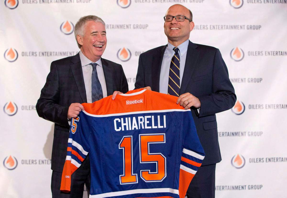 Edmonton Oilers CEO Bob Nicholson, left, and new President and General Manager Peter Chiarelli hold up an Oilers jersey with Chiarelli’s name on it during a press conference in Edmonton, Alta., on Friday April 24, 2015.