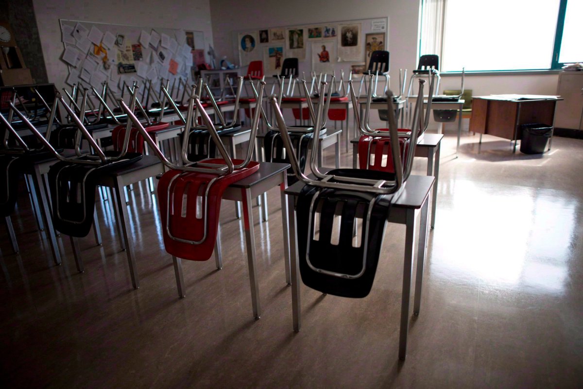 Vacant desks are pictured at the front of a empty classroom.