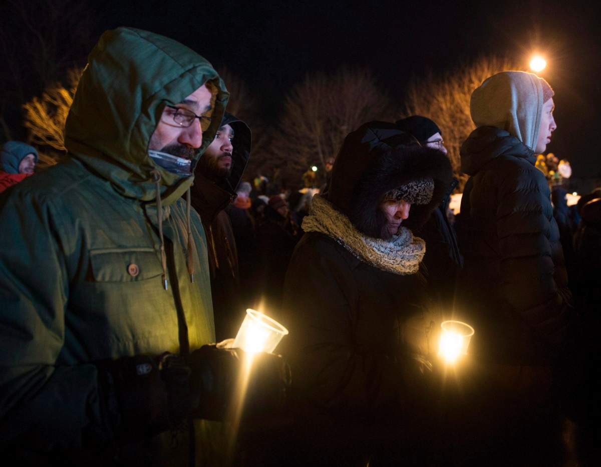 People hold candles at a vigil to commemorate the one-year anniversary of the Quebec City mosque shooting, in Quebec City, Monday, Jan. 29, 2018. 