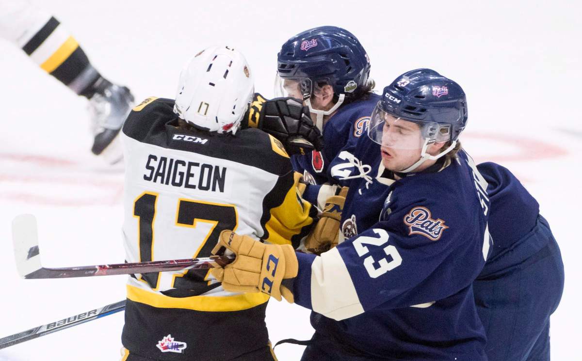 Hamilton Bulldogs' Brandon Saigeon fights for control of the puck with Regina Pats' Brady Pouteau and Sam Steel during the first period of Memorial Cup action in Regina on Friday May, 18, 2018. 