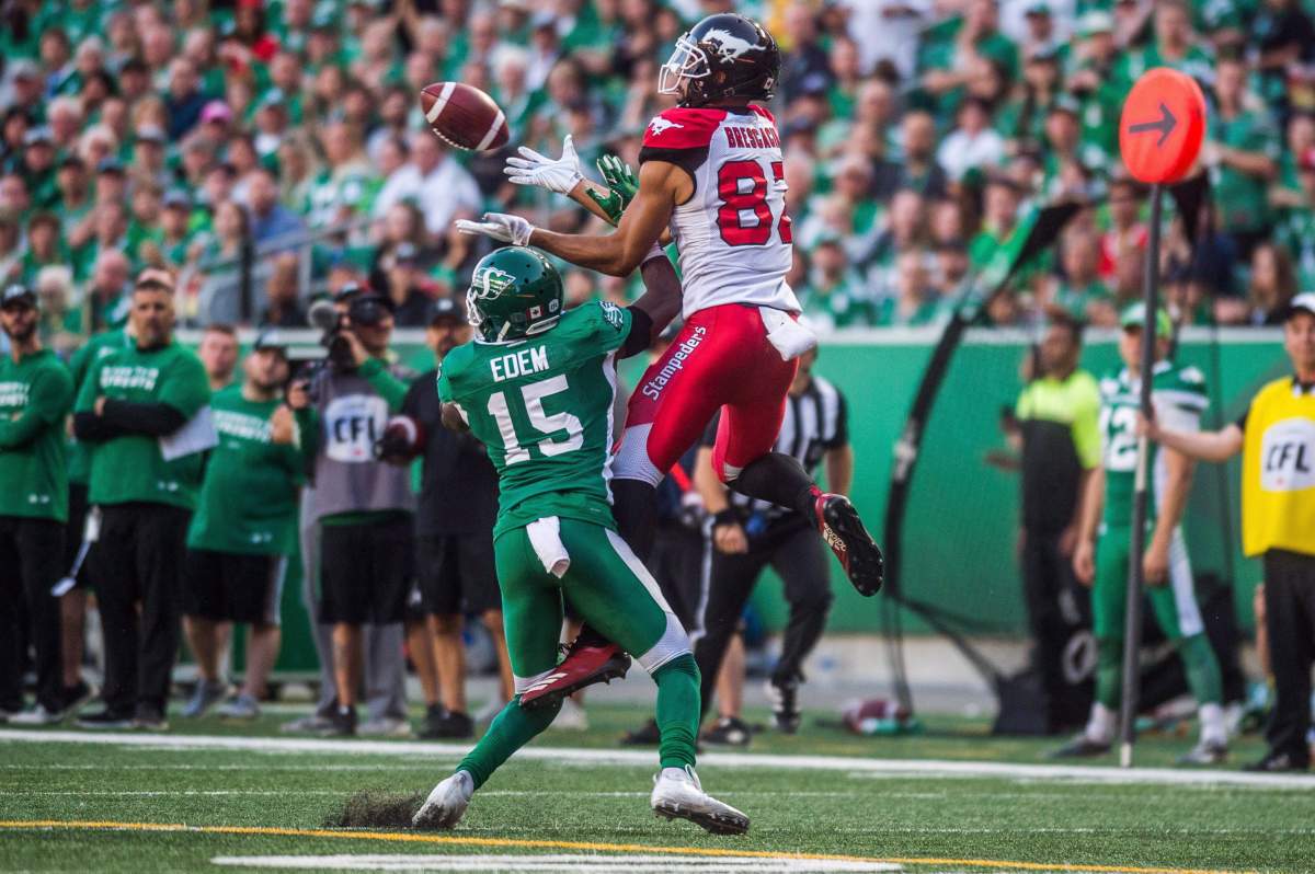 Saskatchewan Roughriders safety Mike Edem (15) tries to block a pass intended for Calgary Stampeders wide receiver Juwan Brescacin (82) during second half CFL action in Regina on Sunday, August 19, 2018. The Saskatchewan Roughriders defeated the Calgary Stampeders 40-27. 