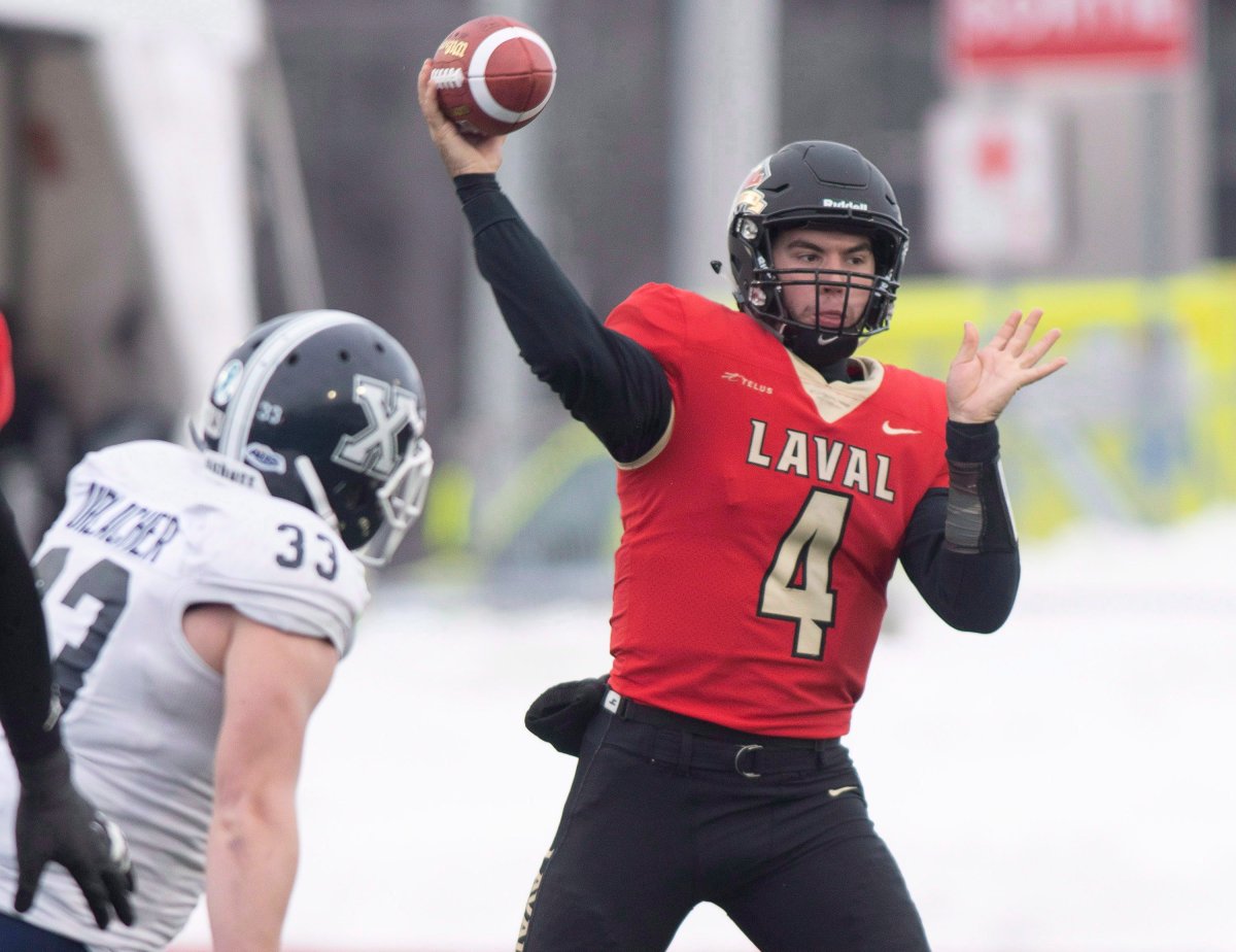 Laval Rouge et Or quarterback Hugo Richard throws a pass during first half action of the Uteck Bowl against St. Francis Xavier X-Men, Saturday, November 17, 2018 at Laval University in Quebec City. St. Francis Xavier X-Men Curtis Urlacher, left, watches the play.
