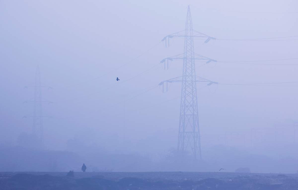 A man walks on the banks of Yamuna river on a foggy winter morning in New Delhi, India, January 3, 2019. 