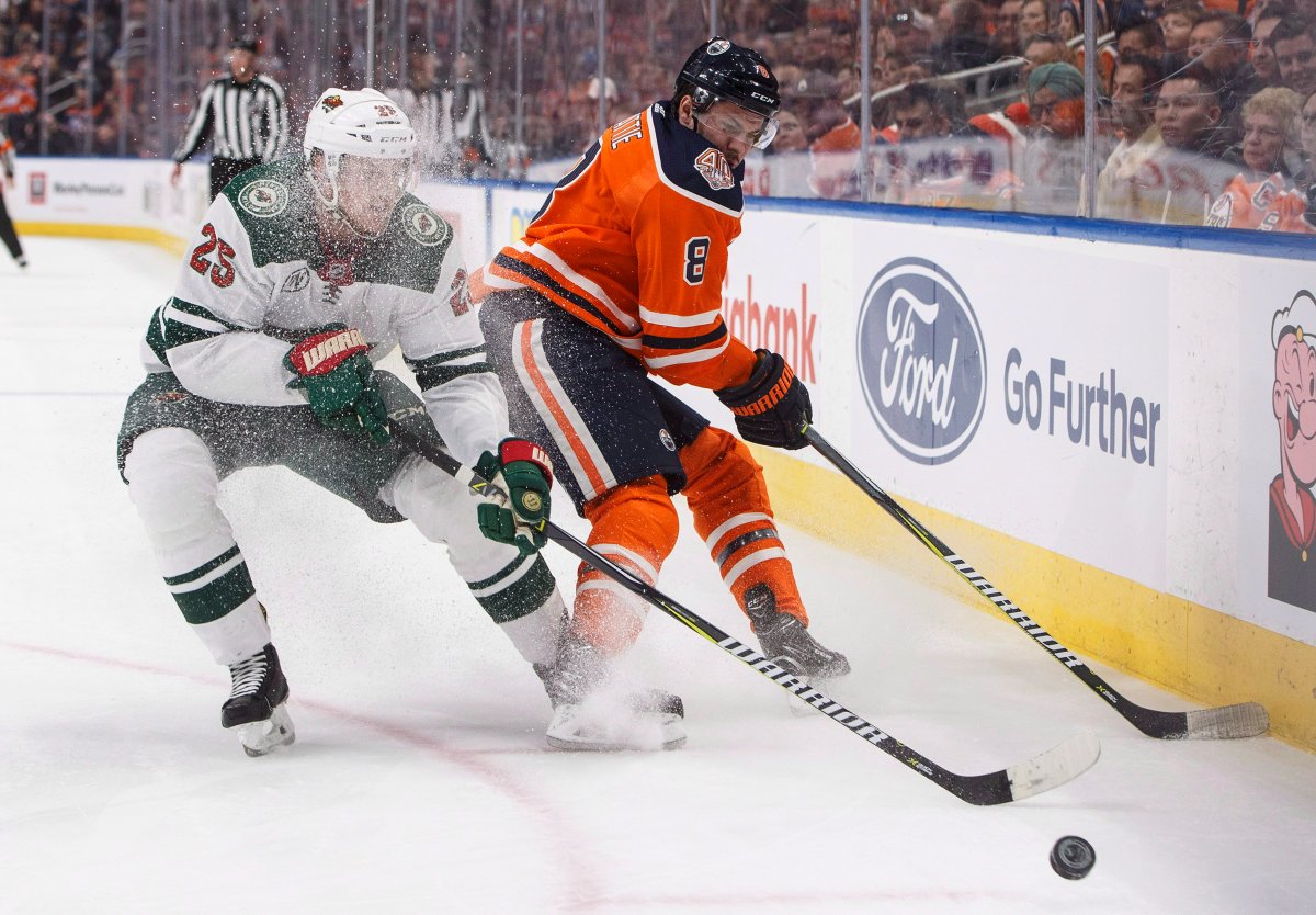 Minnesota Wild defenceman Jonas Brodin (25) and Edmonton Oilers right wing Ty Rattie (8) battle for the puck during second period NHL action in Edmonton, Alta., on Friday December 7, 2018. THE CANADIAN PRESS/Jason Franson.