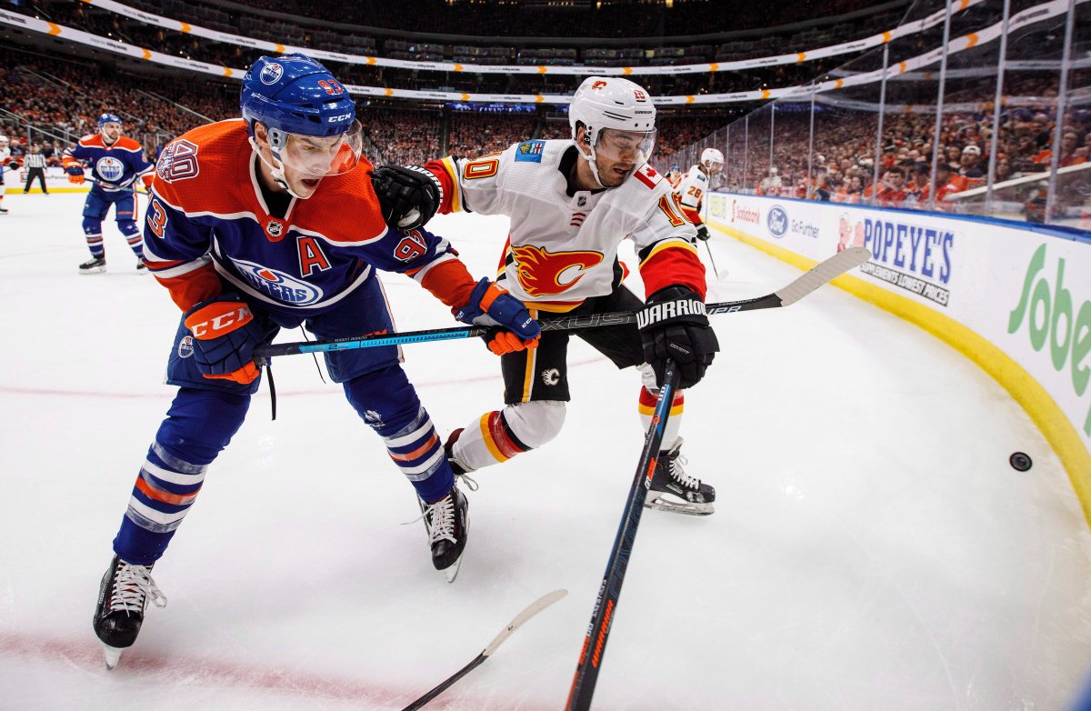 Calgary Flames' Derek Ryan (10) battles for the puck with Edmonton Oilers' Ryan Nugent-Hopkins (93) during third-period NHL action in Edmonton on Sunday, Dec. 9, 2018.