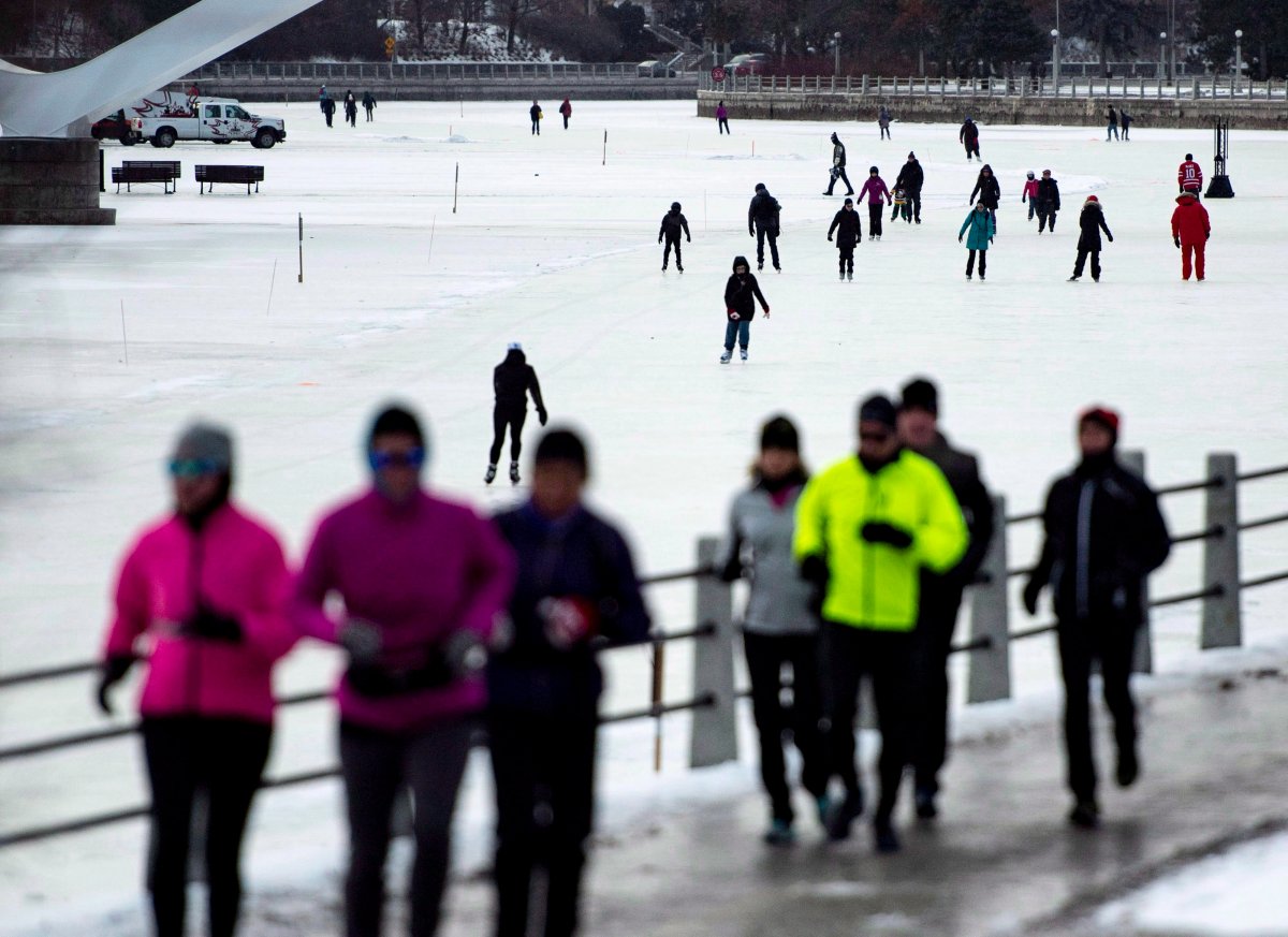 Runners make their way along a path as people skate on the Rideau Canal Skateway on its opening day, in Ottawa on Sunday, Dec. 30, 2018. A 2.7-kilometre section of the skateway opened at 8 a.m. Sunday, marking the earliest start to the skating season since 2004. The Rideau Canal is a UNESCO World Heritage Site.