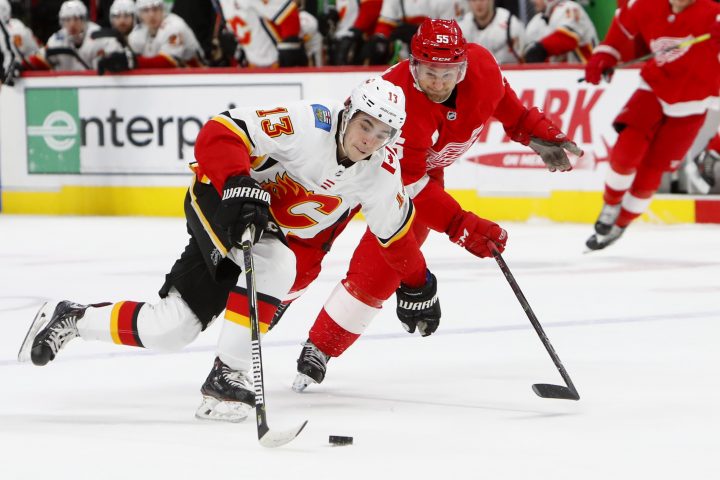 Calgary Flames left wing Johnny Gaudreau (13) protects the puck from Detroit Red Wings defenseman Niklas Kronwall (55) in the third period of an NHL hockey game Wednesday, Jan. 2, 2019, in Detroit.
