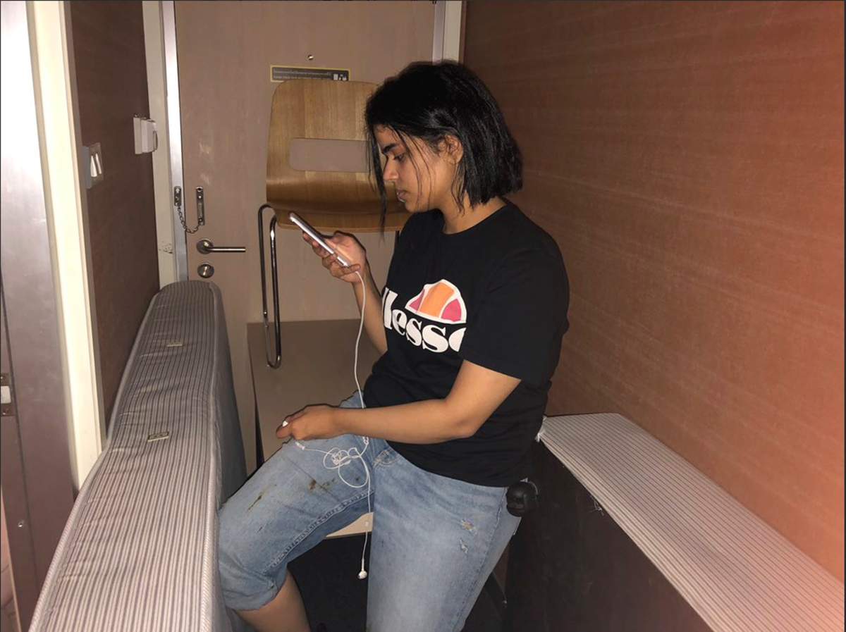 Rahaf Mohammed al-Qunun views her mobile phone as she sits barricaded in a hotel room at an international airport in Bangkok, Thailand.